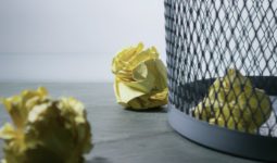focus photo of yellow paper near trash can